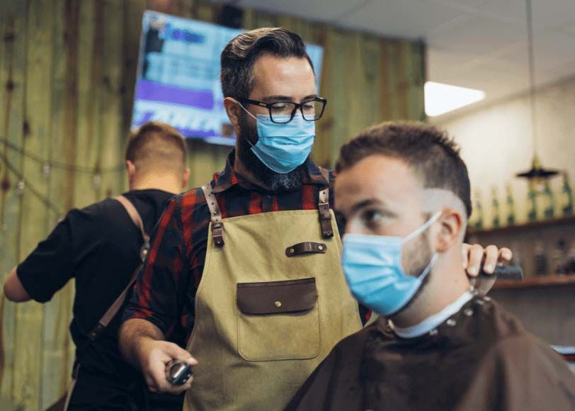 Male barber shop owner cutting a customer's hair