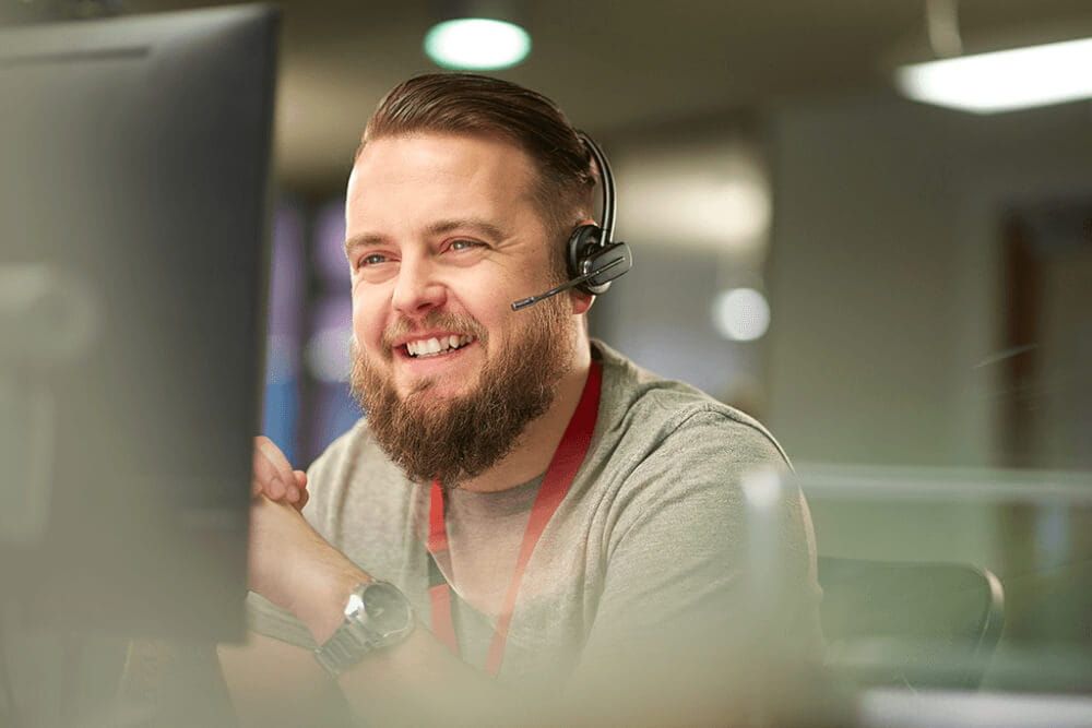 Atom Telephone Business Development Manager wearing a headset while assisting a broker.